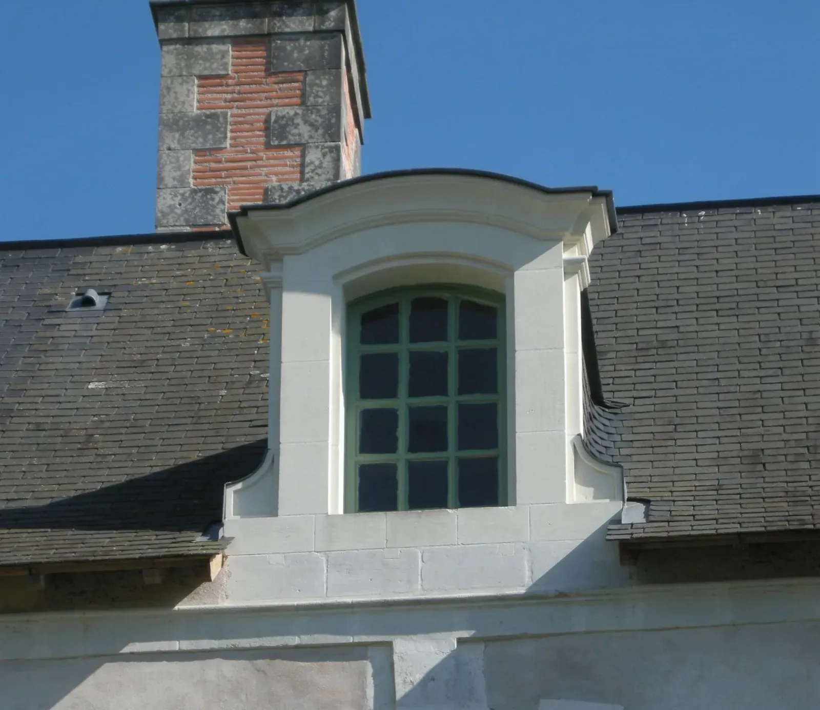 Lucarne en pierre de taille sur toiture en ardoise
