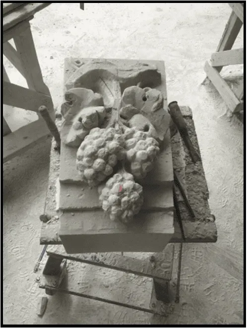 Clé d'arc sculptée d'une grappe et d'une feuille de vigne